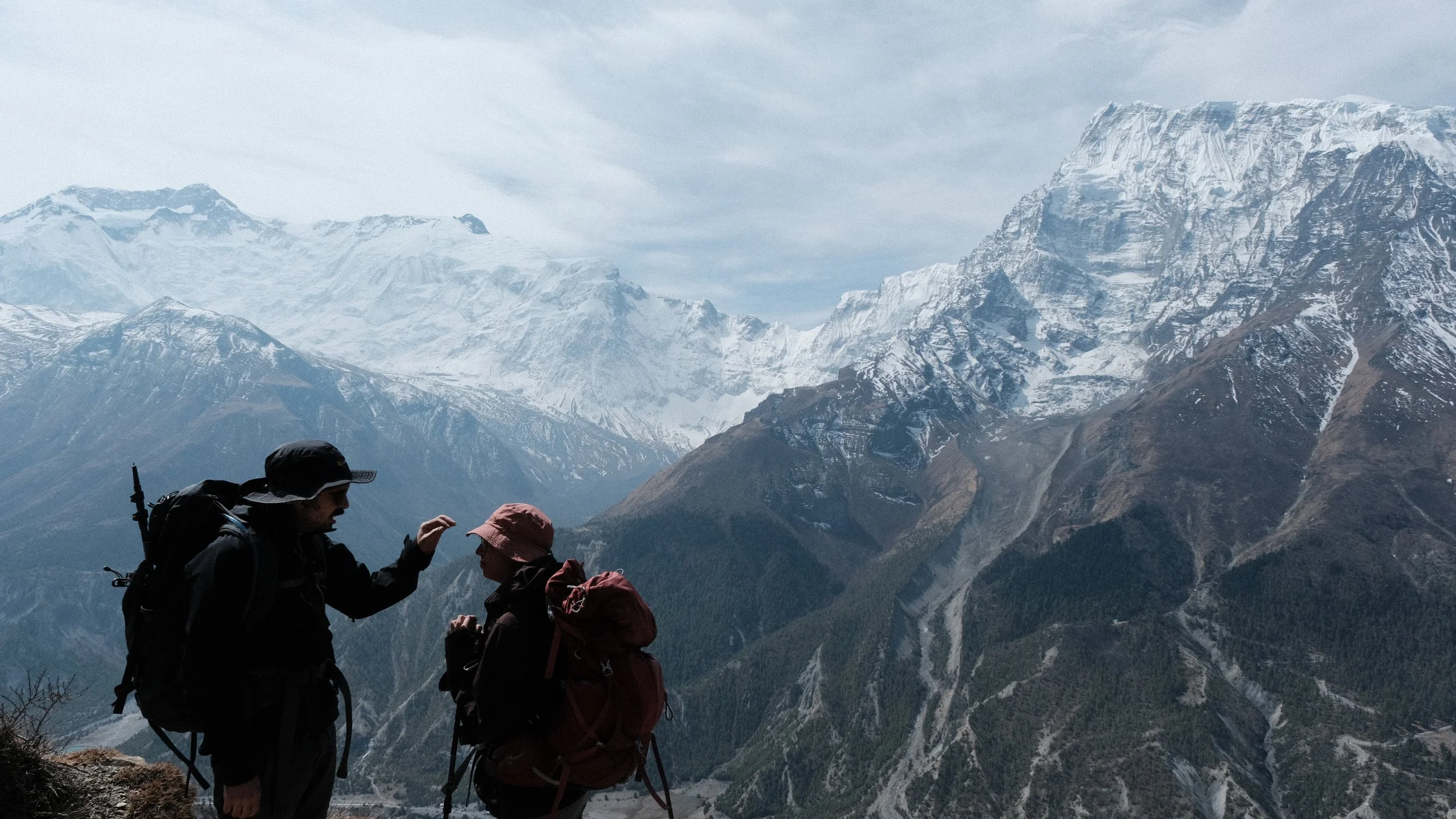 Pareja en Nepal con montañas nevadas al fondo.