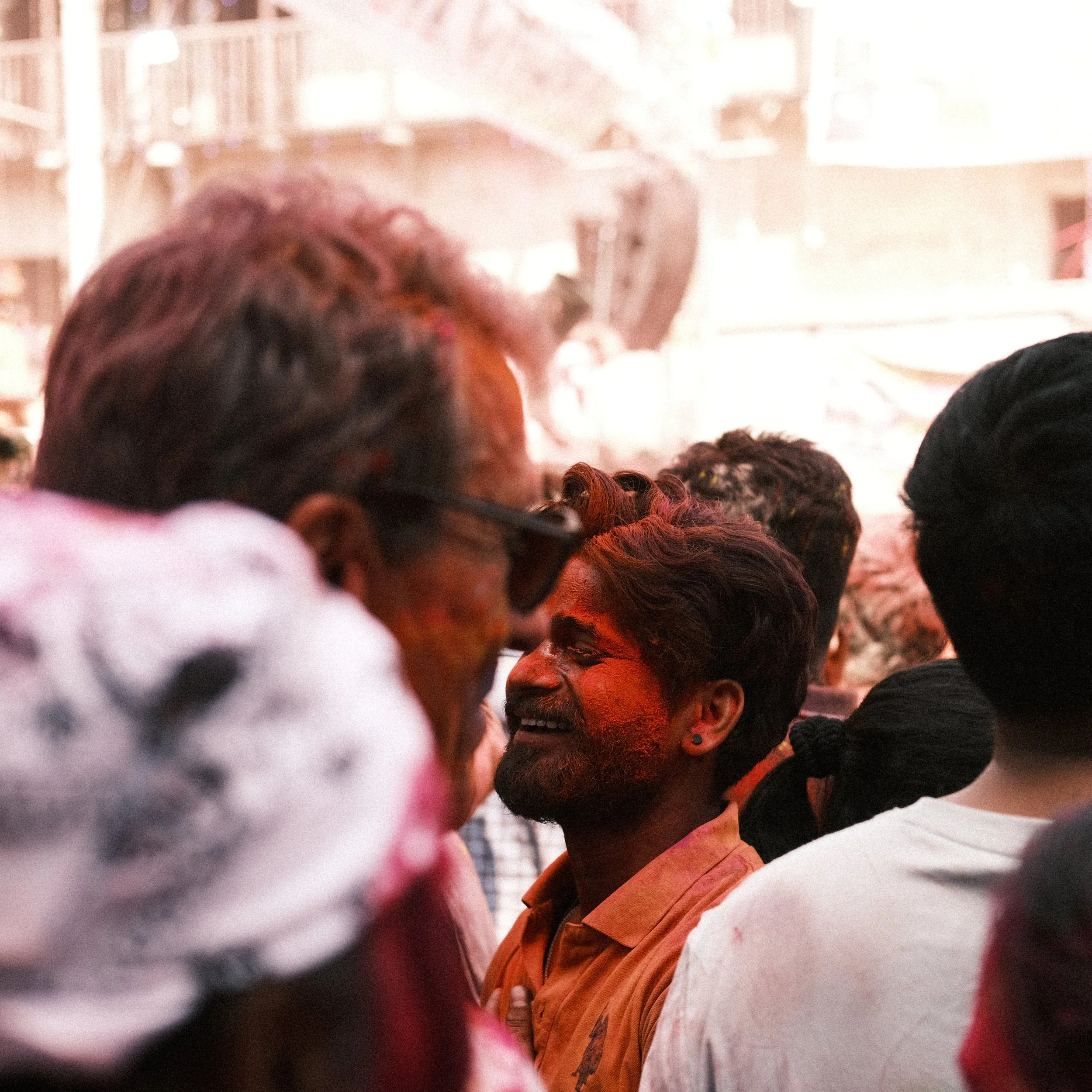 Hombre sonriendo con la cara llena de color durante Holi en India