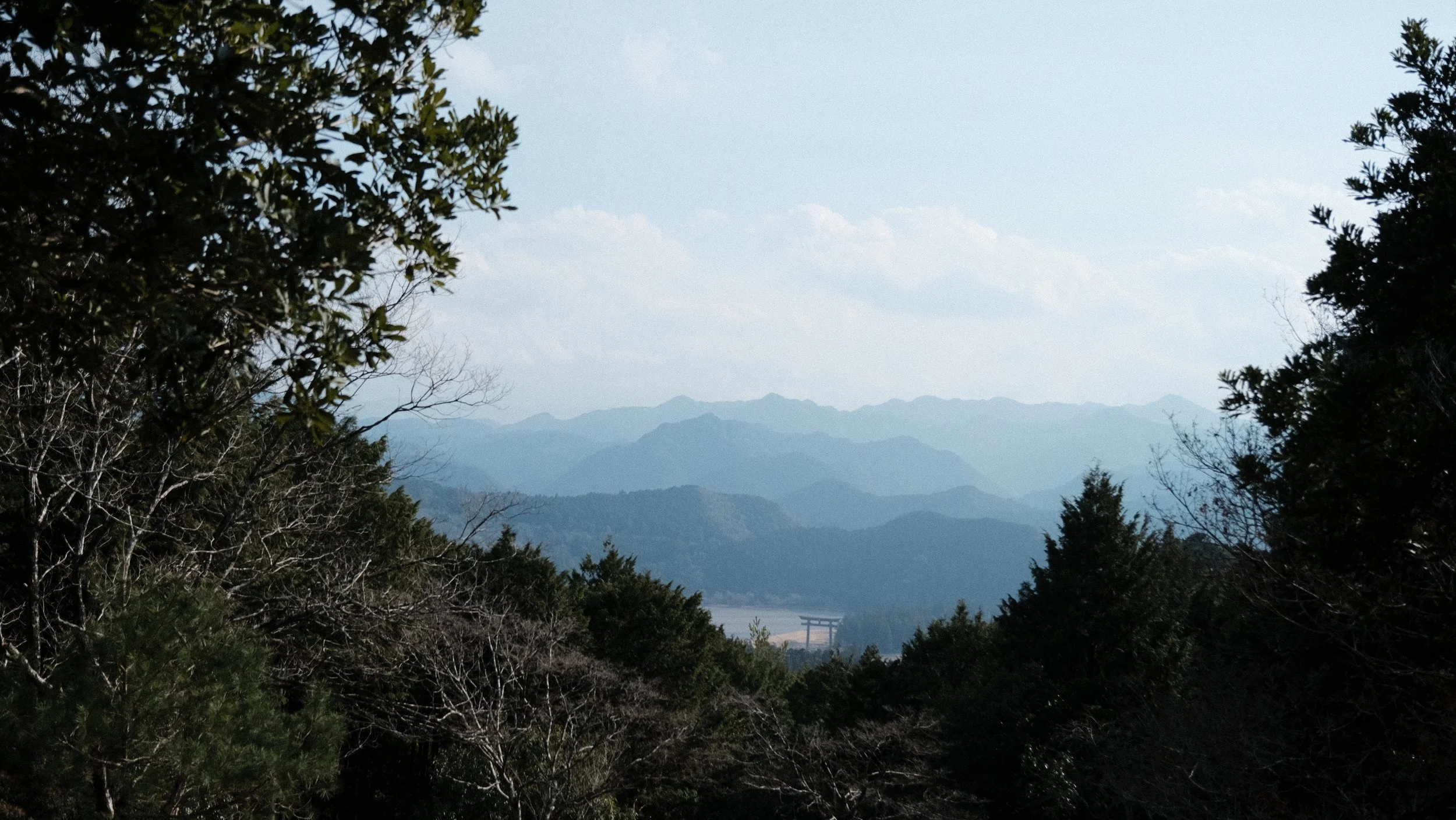 Paisaje montañoso en Japón con una puerta Torii al fondo.