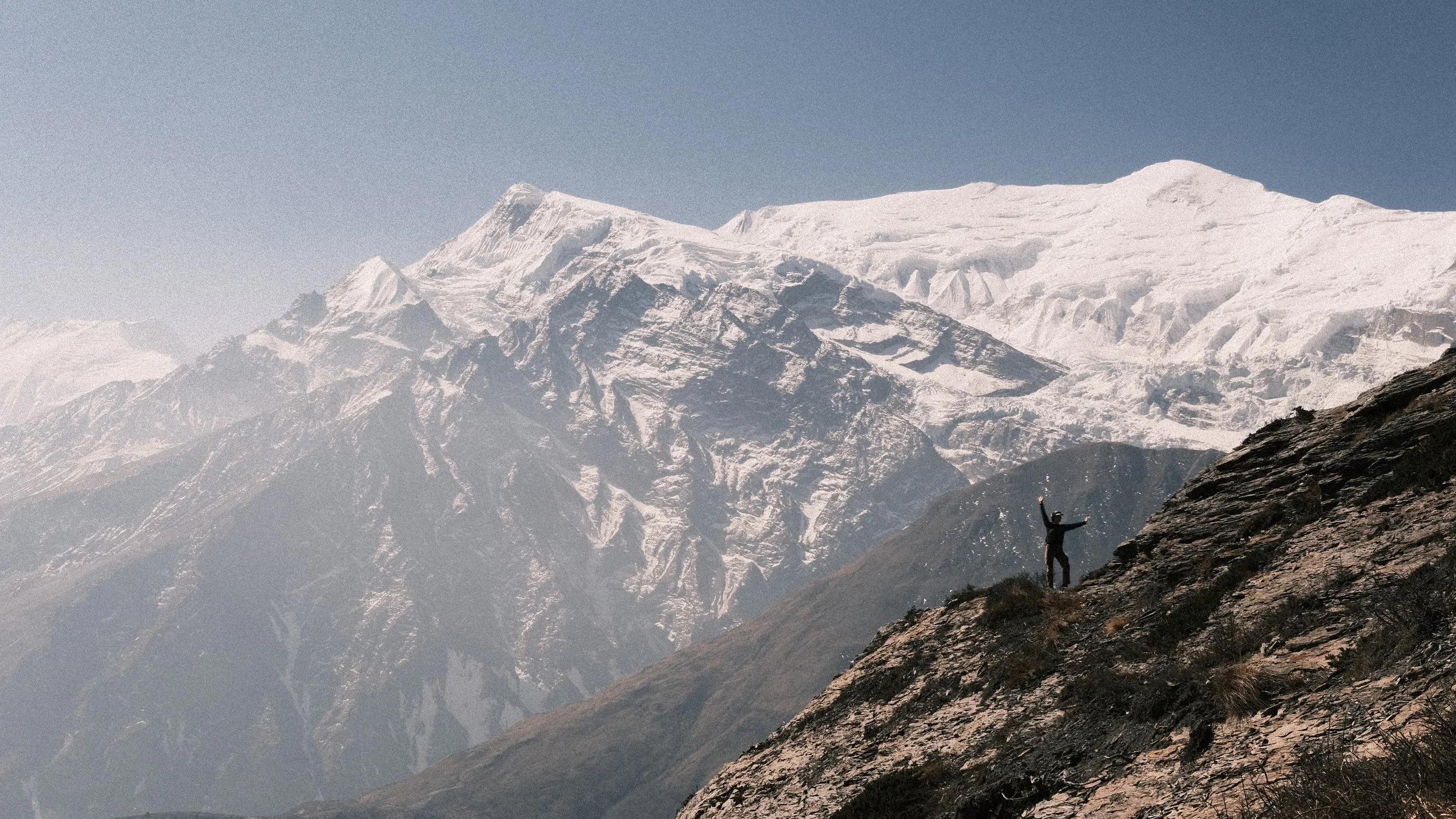 Persona posando con los Himalayas detrás en Nepal.