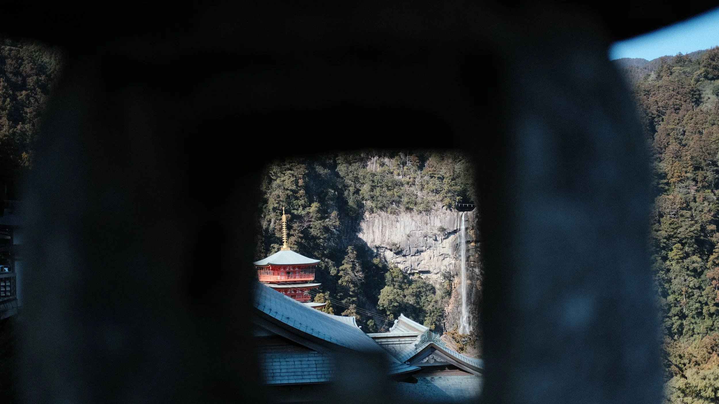 La pagoda de Nachi Taisha y la cascada Nachi, en el Kumano Kodo, enmarcadas por la apertura de una linterna.