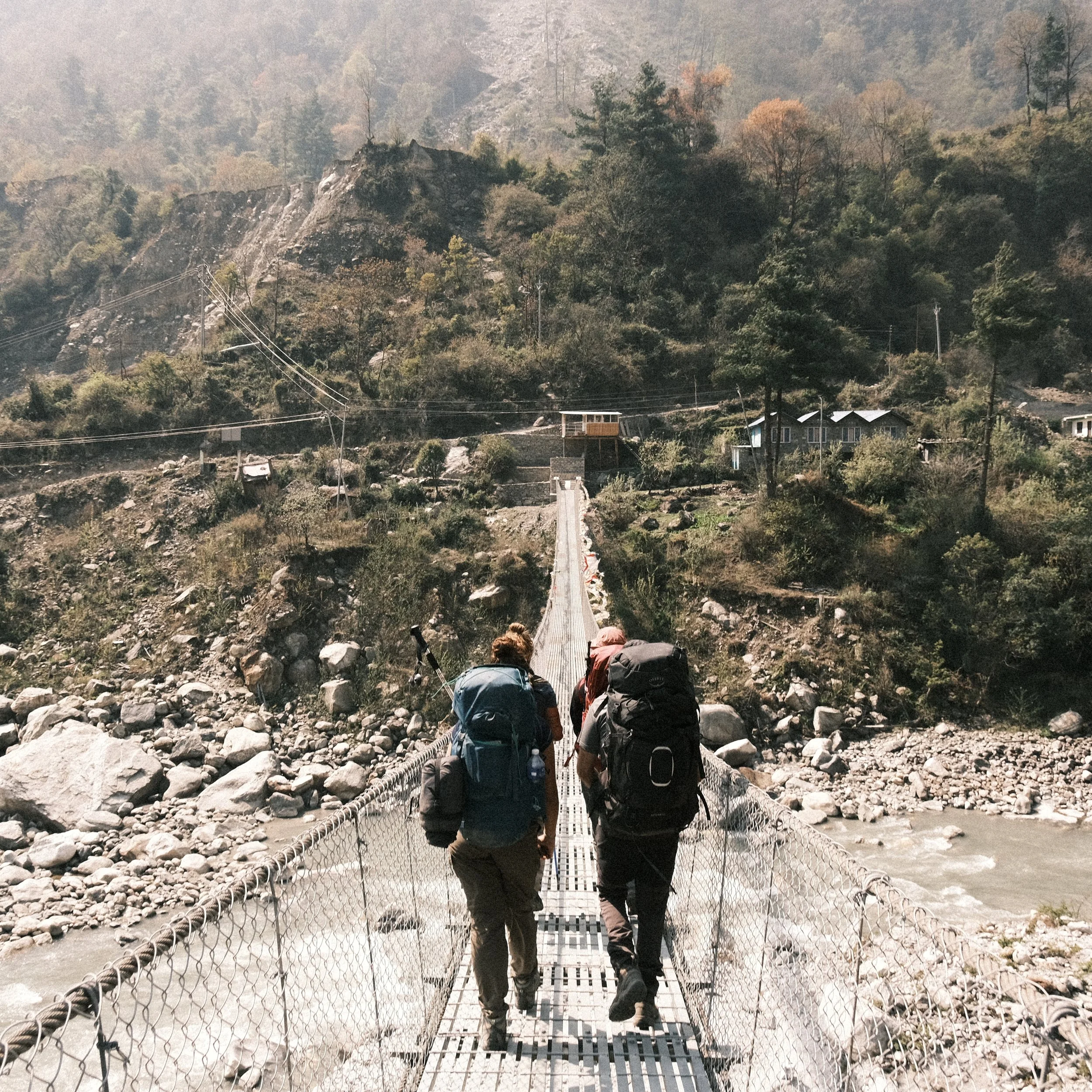 Personas pasando un puente en el circuito de Annapurna