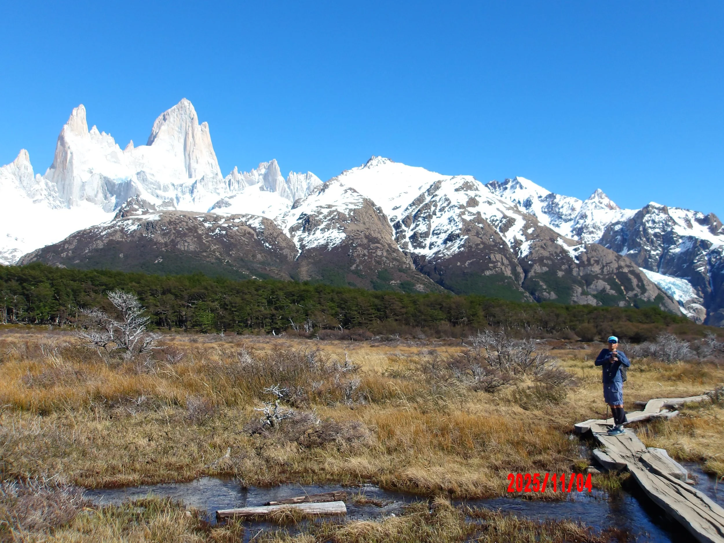 Persona sobre un puente de madera con el Fitz Roy detrás, en Patagonia, Argentina.