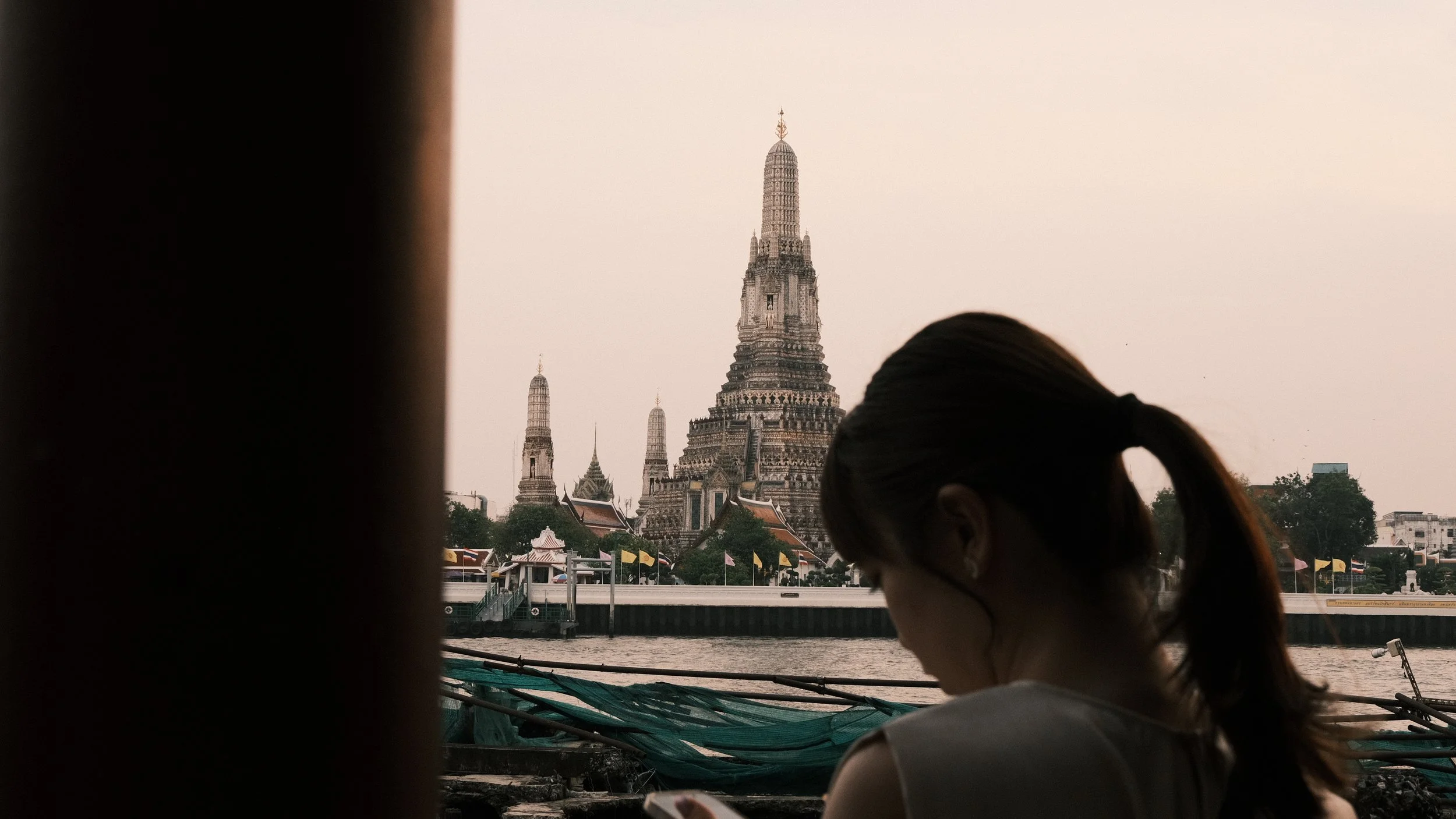 Mujer con el templo de Wat Arum detrás en Bangkok