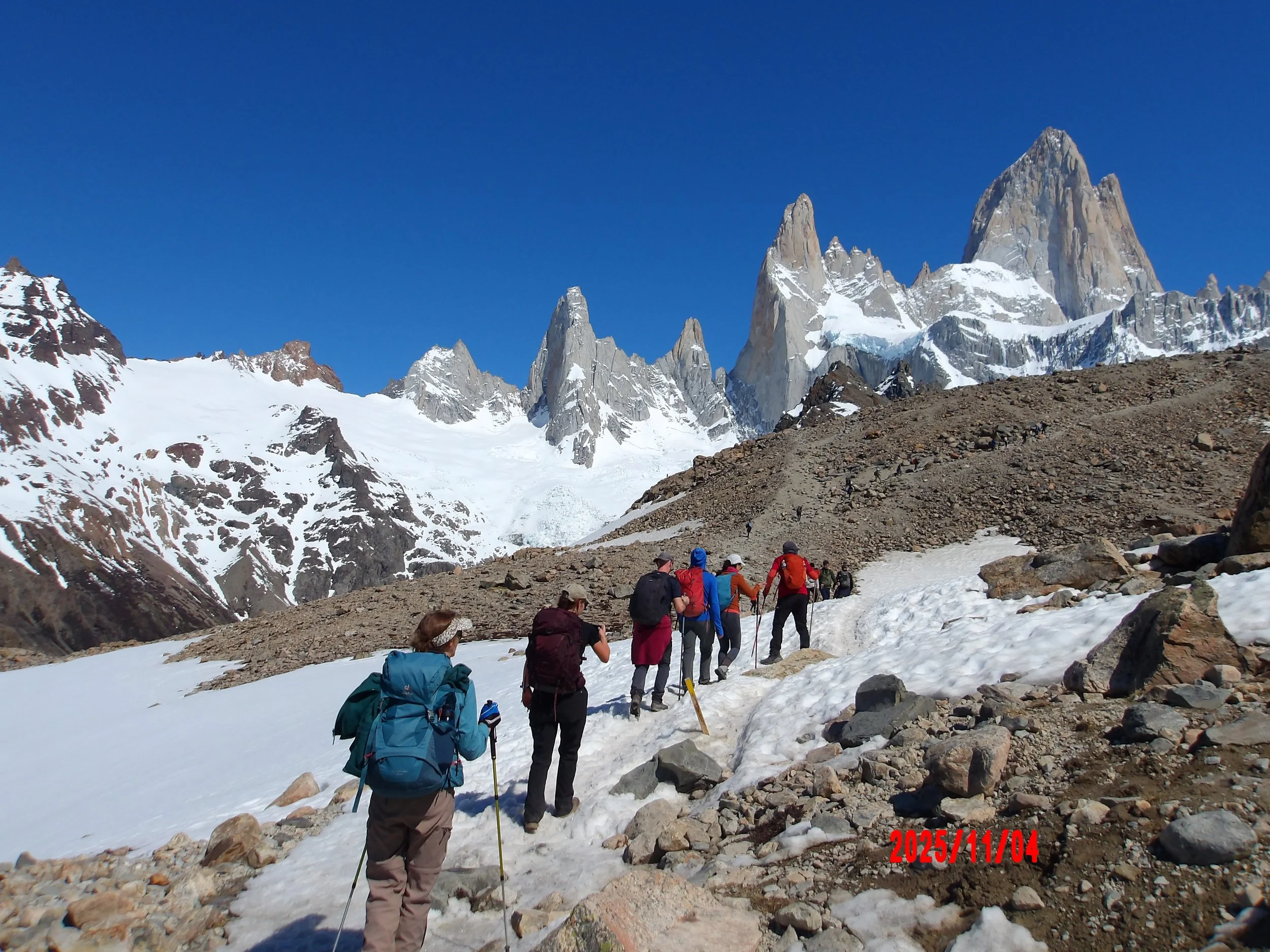 Personas caminando sobre hielo con el Fitz Roy al fondo
