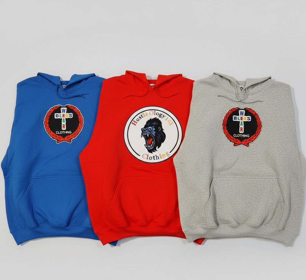 Three hoodies in blue, red, and gray displayed on a white surface, each with logo patches on the front.