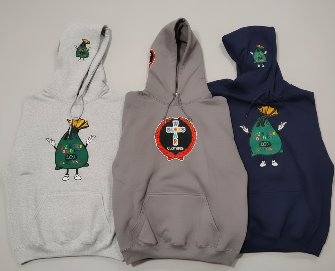Three hoodies with colorful embroidered designs on the front. The left gray hoodie features a green bag character with the text "NUSTLE OOGLE 40L Clothing". The middle beige hoodie has a circular patch with the words "W BLES S A R" and "Clothing" ins