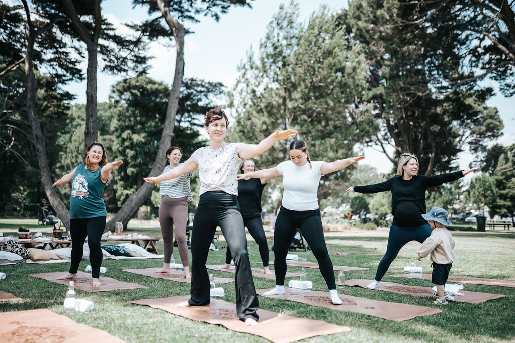 Premium Pilates mats and elegant glassware arranged for a Pilates Picnic Melbourne experience, set amongst nature in a beautiful outdoor location.