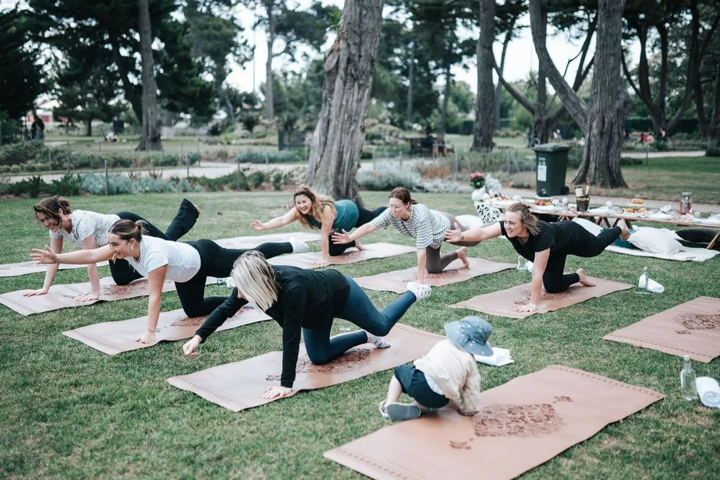 Guests participating in an outdoor Pilates session as part of a luxury Pilates and picnic experience in Melbourne.
