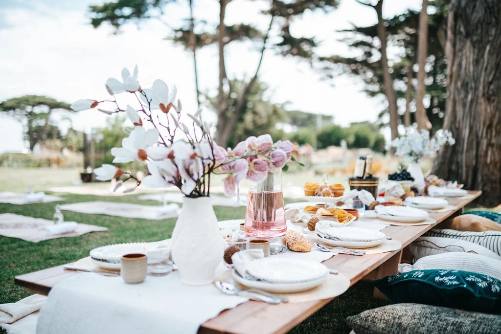 Luxury picnic experience in Melbourne featuring elegant table styling, floral arrangements, and a scenic outdoor setting.
