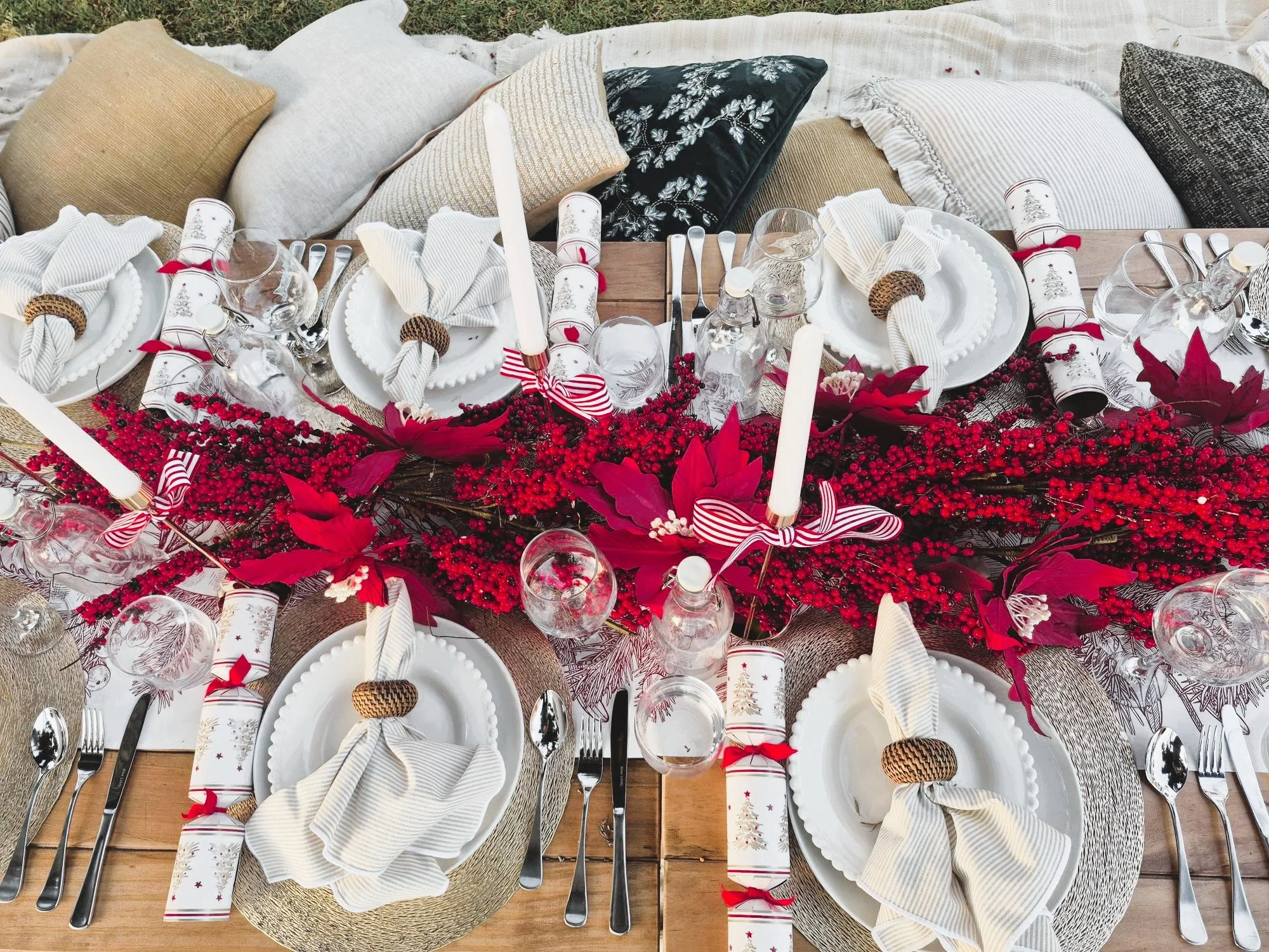 Elegant picnic table styling featuring premium tableware, linen napkins, glassware, and beautiful floral details.