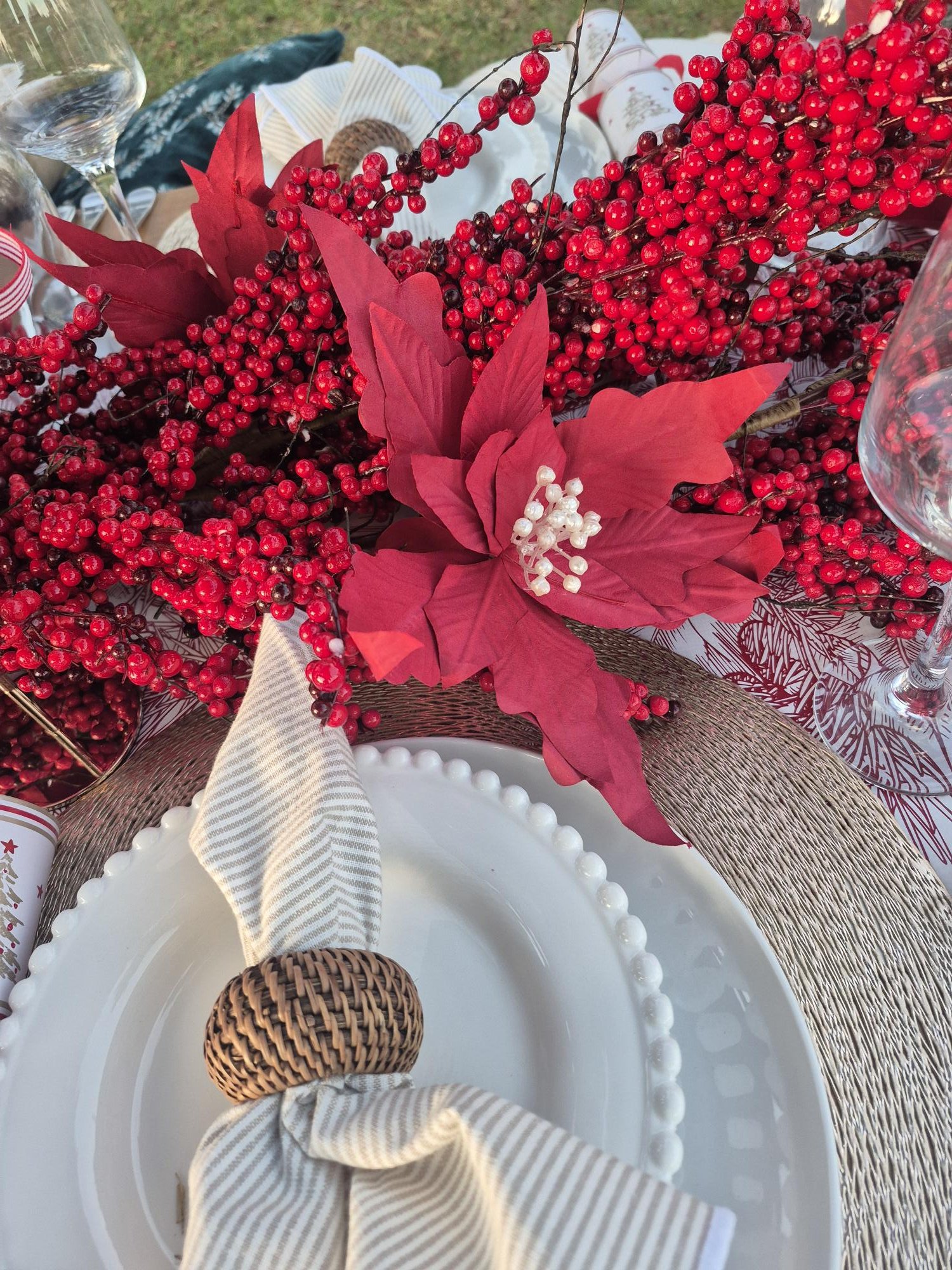 Elegant picnic table styling featuring premium tableware, seasonal floral accents, linen napkins, and beautifully considered decorative details.