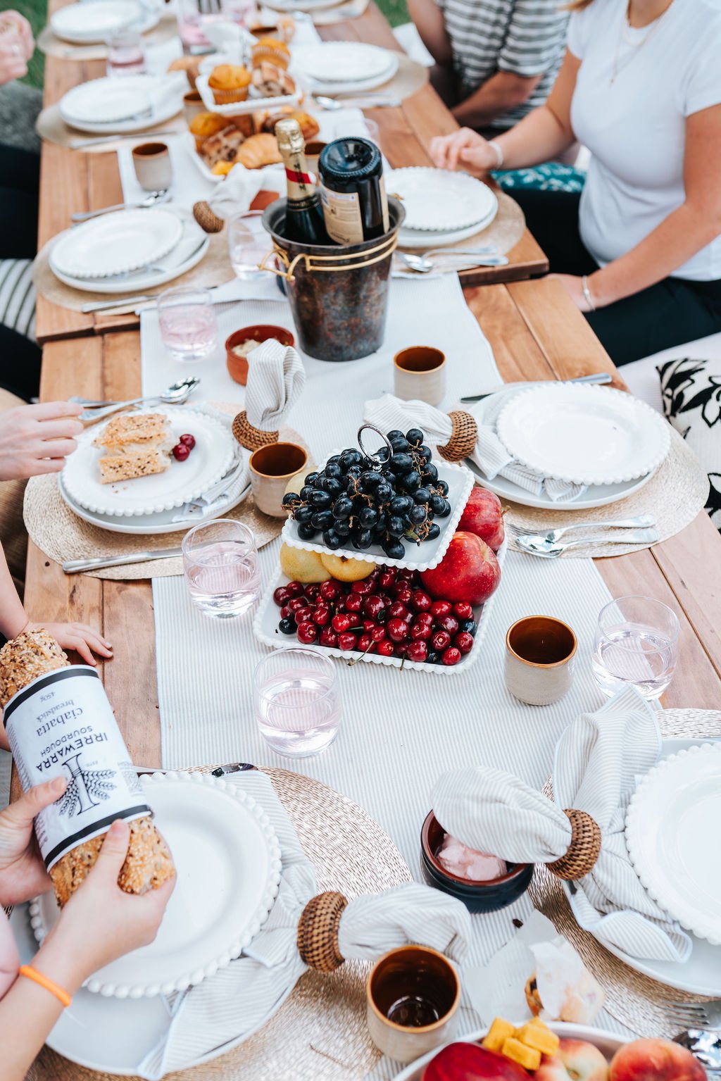Luxury picnic experience in Melbourne featuring a beautifully styled brunch table with fresh fruit, pastries, refreshments, and outdoor dining.