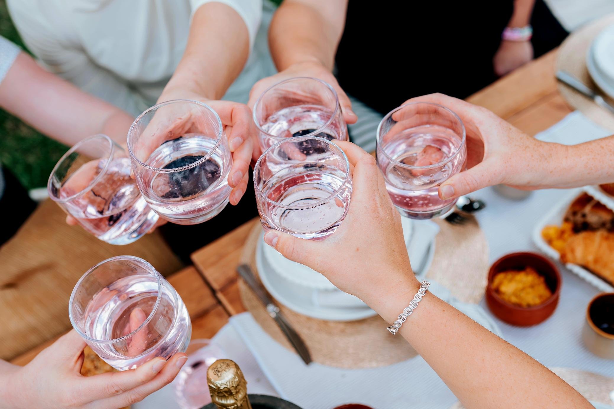 Guests celebrating with refreshments during a Pilates Picnic Melbourne experience, enjoying connection and conversation in a beautiful outdoor setting.