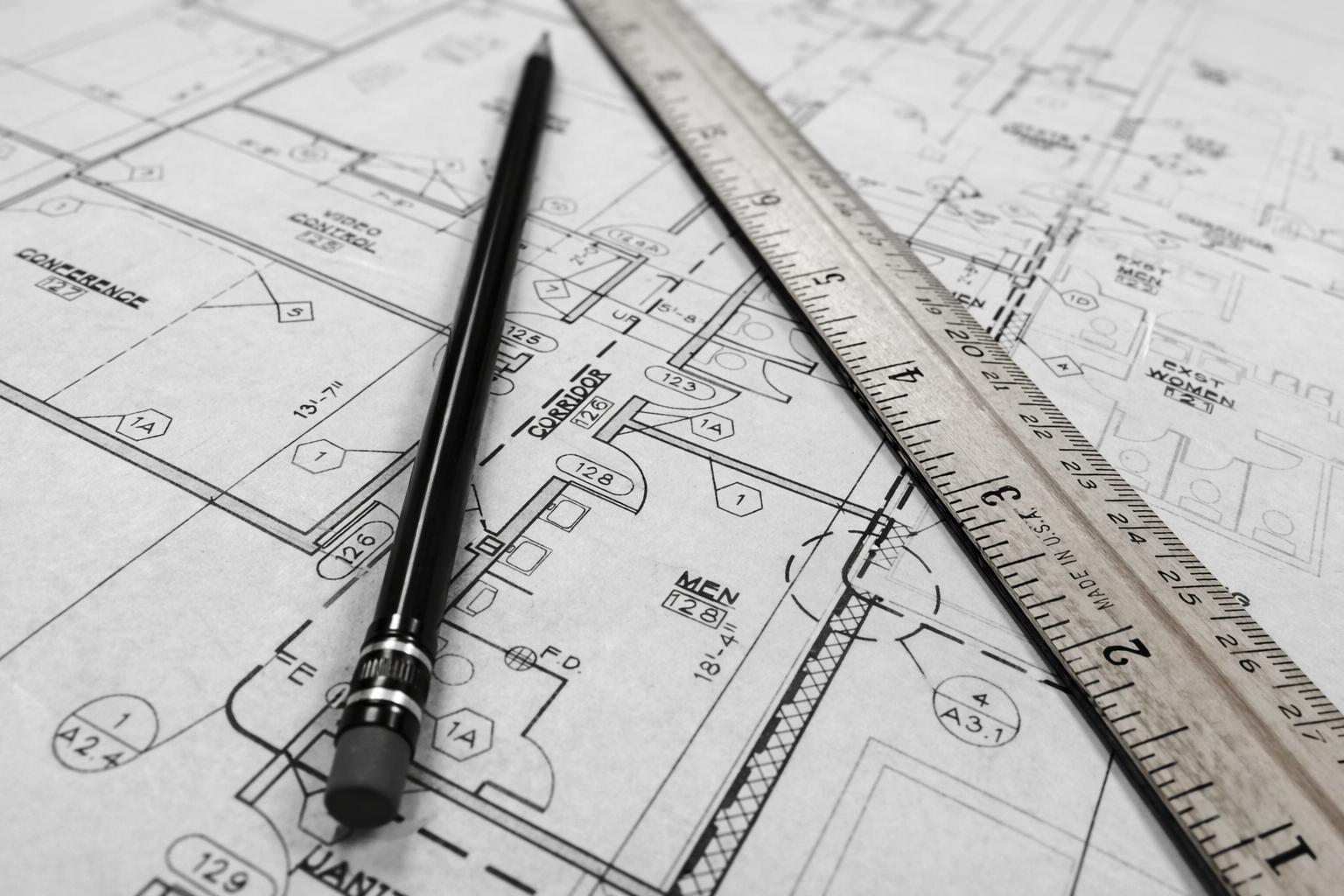 Architectural floor plans with pencil and ruler used for planning commercial carpet tile flooring installation