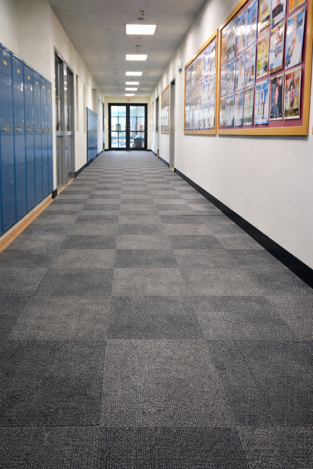Commercial carpet tile flooring installed in a busy school corridor with lockers and notice boards in a UK education building