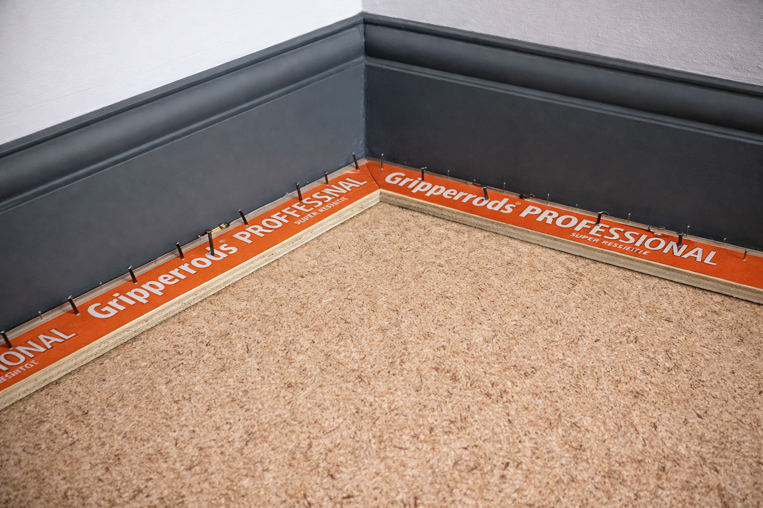 Carpet gripper rods installed neatly along skirting boards ready for carpet fittingCarpet gripper rods installed neatly along skirting boards ready for carpet fitting