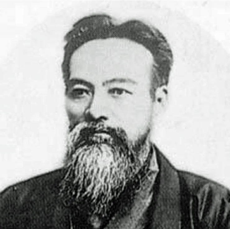 Black and white photograph of a man with a full beard and mustache, wearing traditional Chinese clothing.
