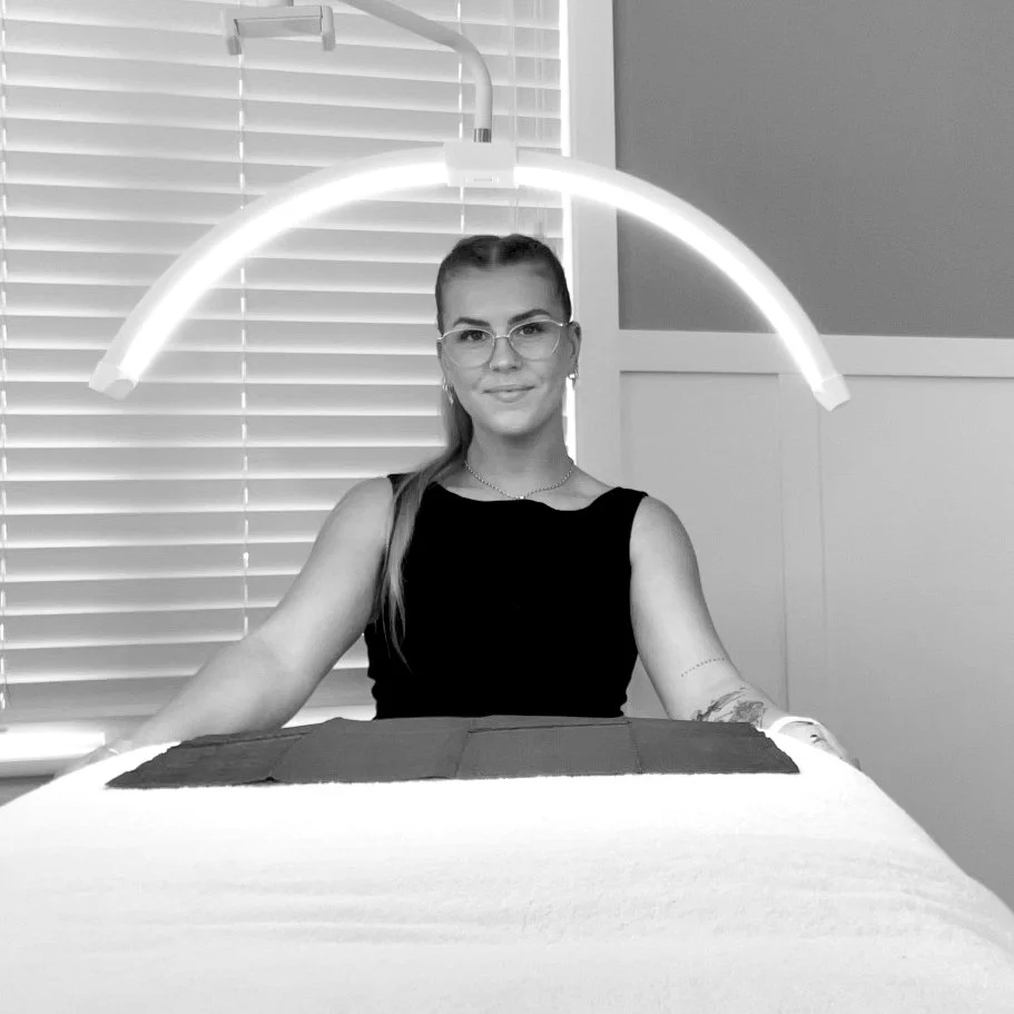 Keilah smiling and looking at the camera ready to provide a treatment.