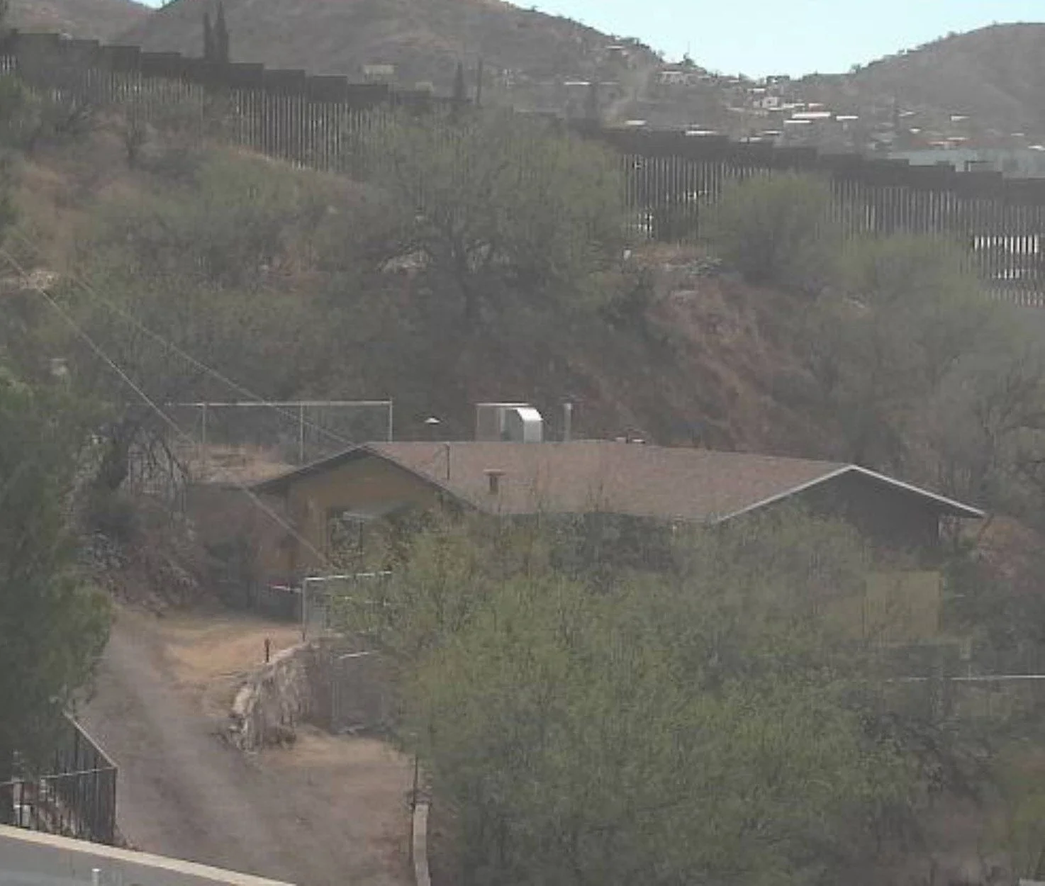 A house in Nogales, AZ, indistinguishable from every other home on the street. That's the point. Beneath it, a tunnel connected the US side to Mexico. The border fence visible in the background was irrelevant since the network was already underneath 