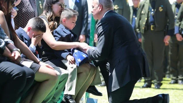 DHS Secretary Jeh Johnson presented a folded American flag to the widow of fallen Border Patrol Agent Jose “Joey” Barraza. (Photo © Victor Calzada / El Paso Times via Imagn Images, used with permission.)