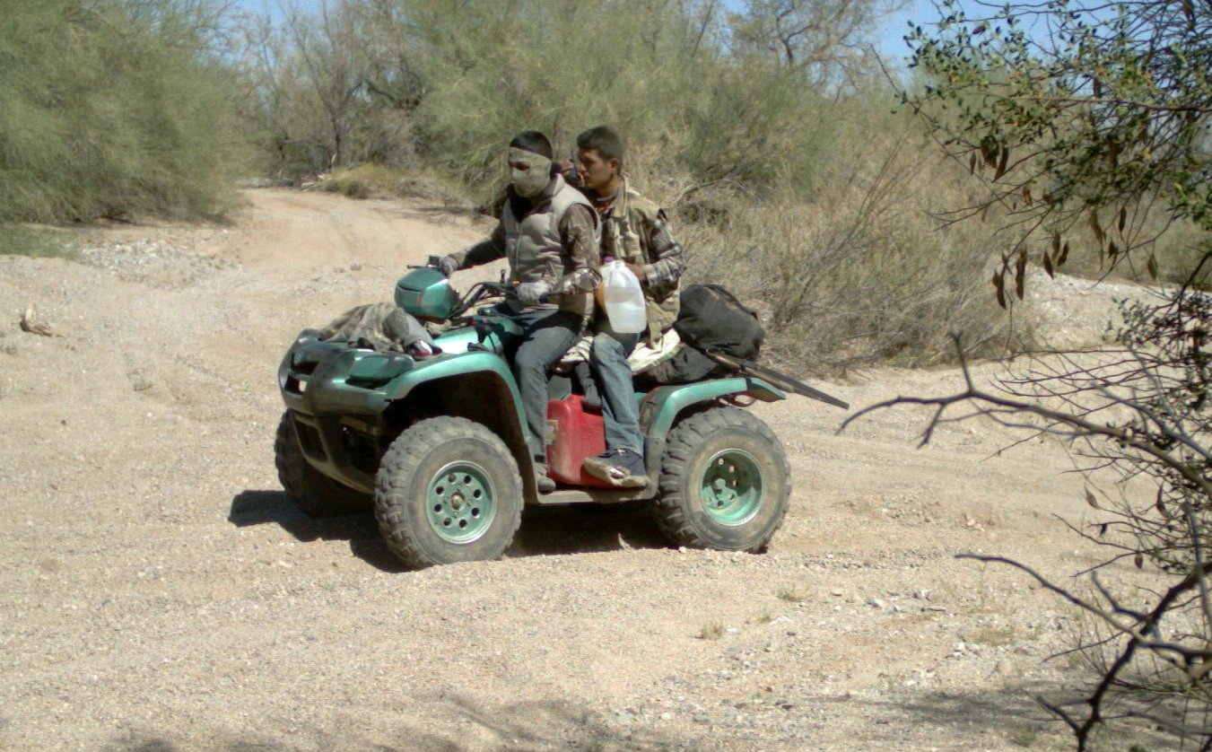 Two of El Memo's traffickers head south after dropping a marijuana load at a nearby stash house and were already resupplying for the next run. The rear passenger uses an encrypted radio to coordinate with mountain scouts. Carpet booties on their shoe