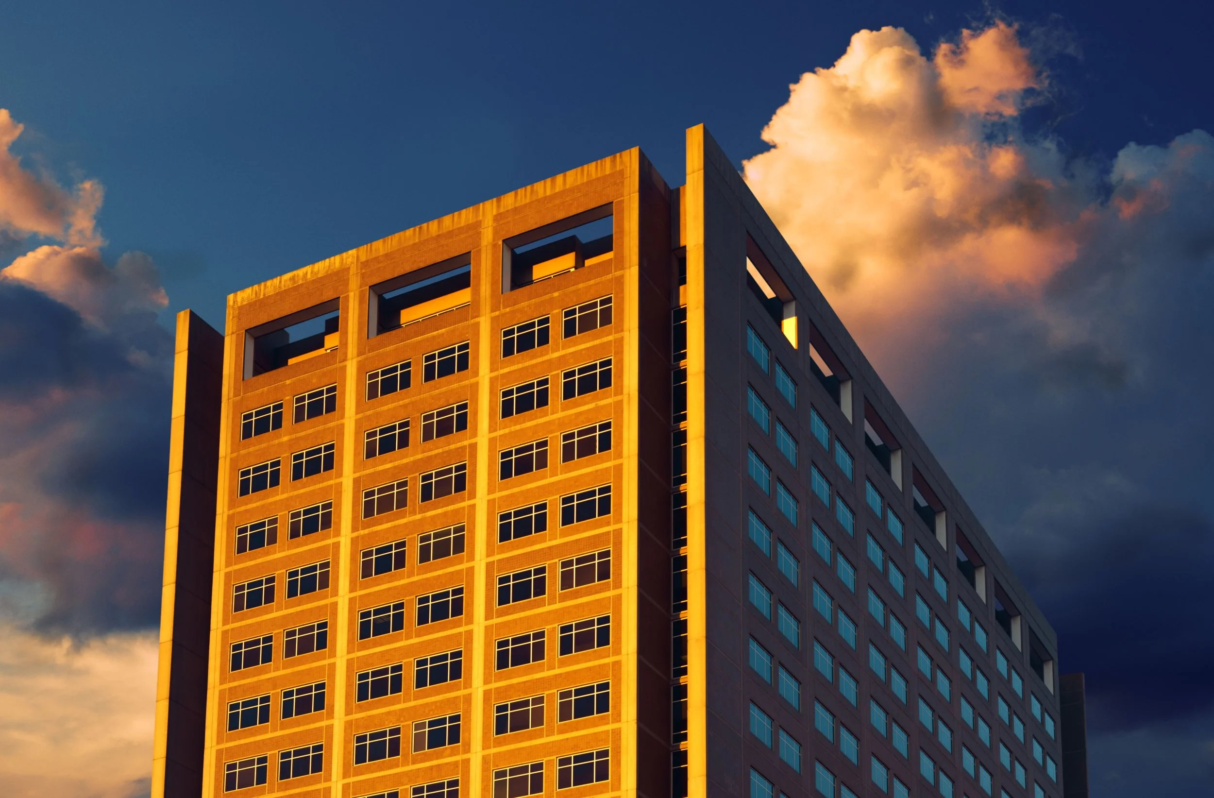 Surreal International Style building in deep golden light and cold shadow under a dark blue sky. Fine art photography.
