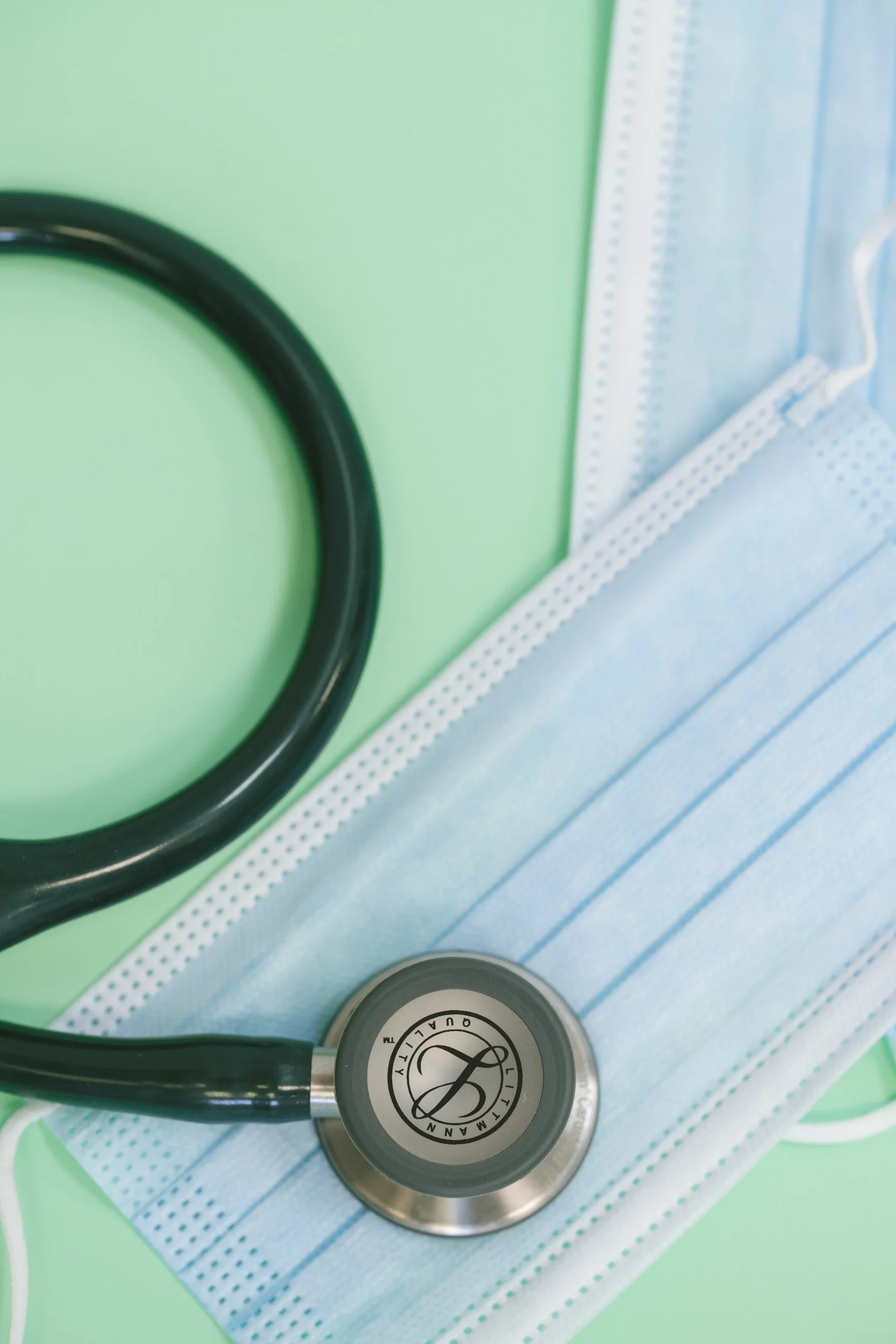 Close-up of a stethoscope resting on a blue medical face mask