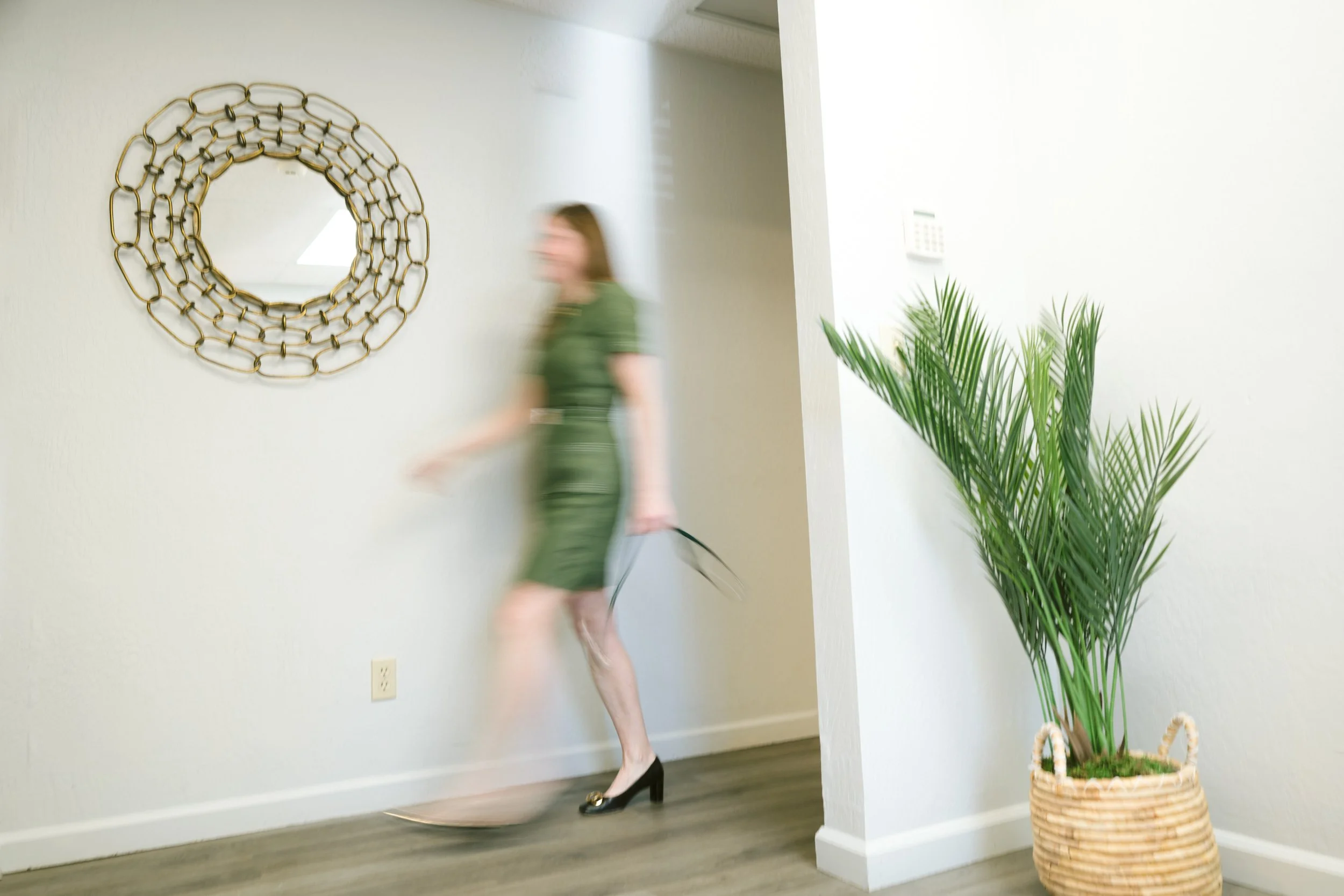 Branded collage featuring office details and a blurred woman Dr. Christina Harding in a green dress walking through a bright interior