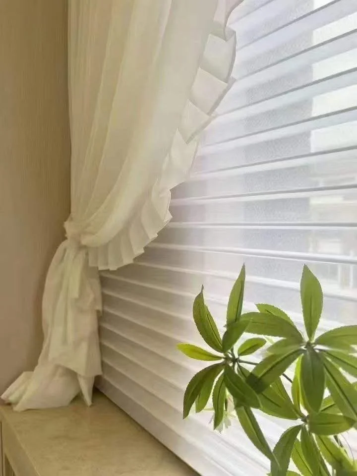 White sheer curtains with decorative frill tied to the side, white Shangri-la blinds