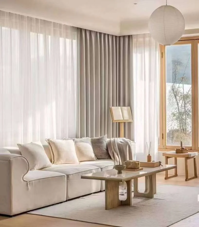 Bright, modern living room with 2 track curtain system consisting of sheer and biege curtains on a curved track