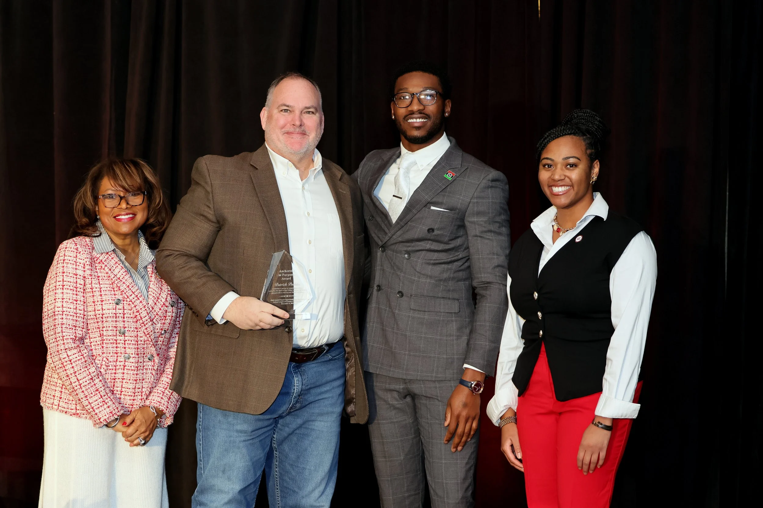 ULGC Anchored in Purpose Award Winner Patrick Parks Standing with ULGC leaders holding Award