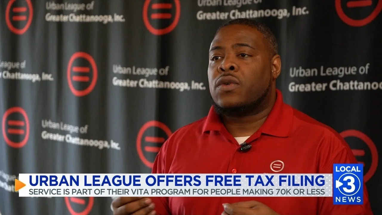 A man in a red shirt speaking during a news segment about the Urban League offering free tax filing services as part of their VITA program for people making 70K or less.