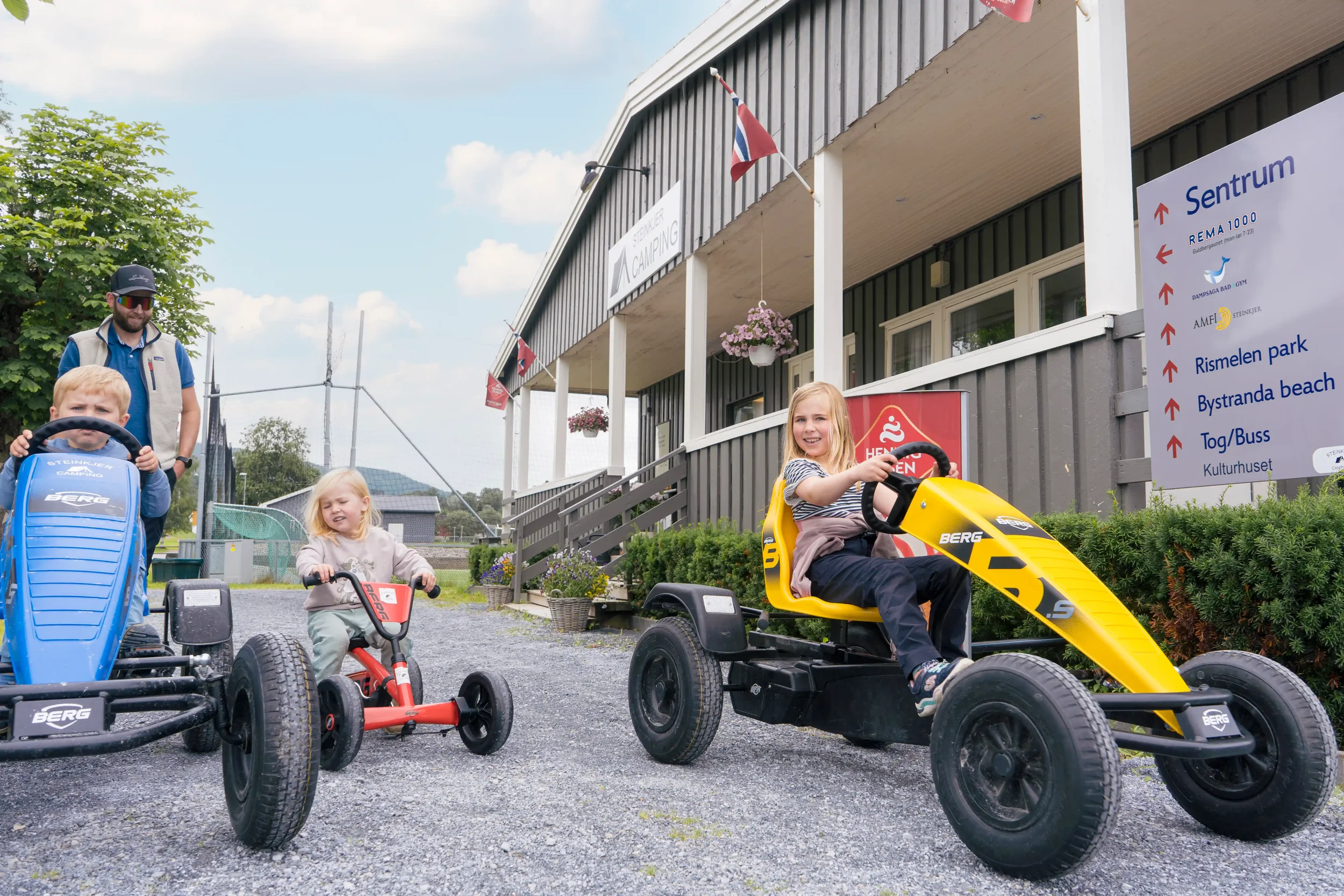 Barn og voksne som kjører små elektriske go-karts utenfor Steinkjer Camping. Foto: Scott Aune
