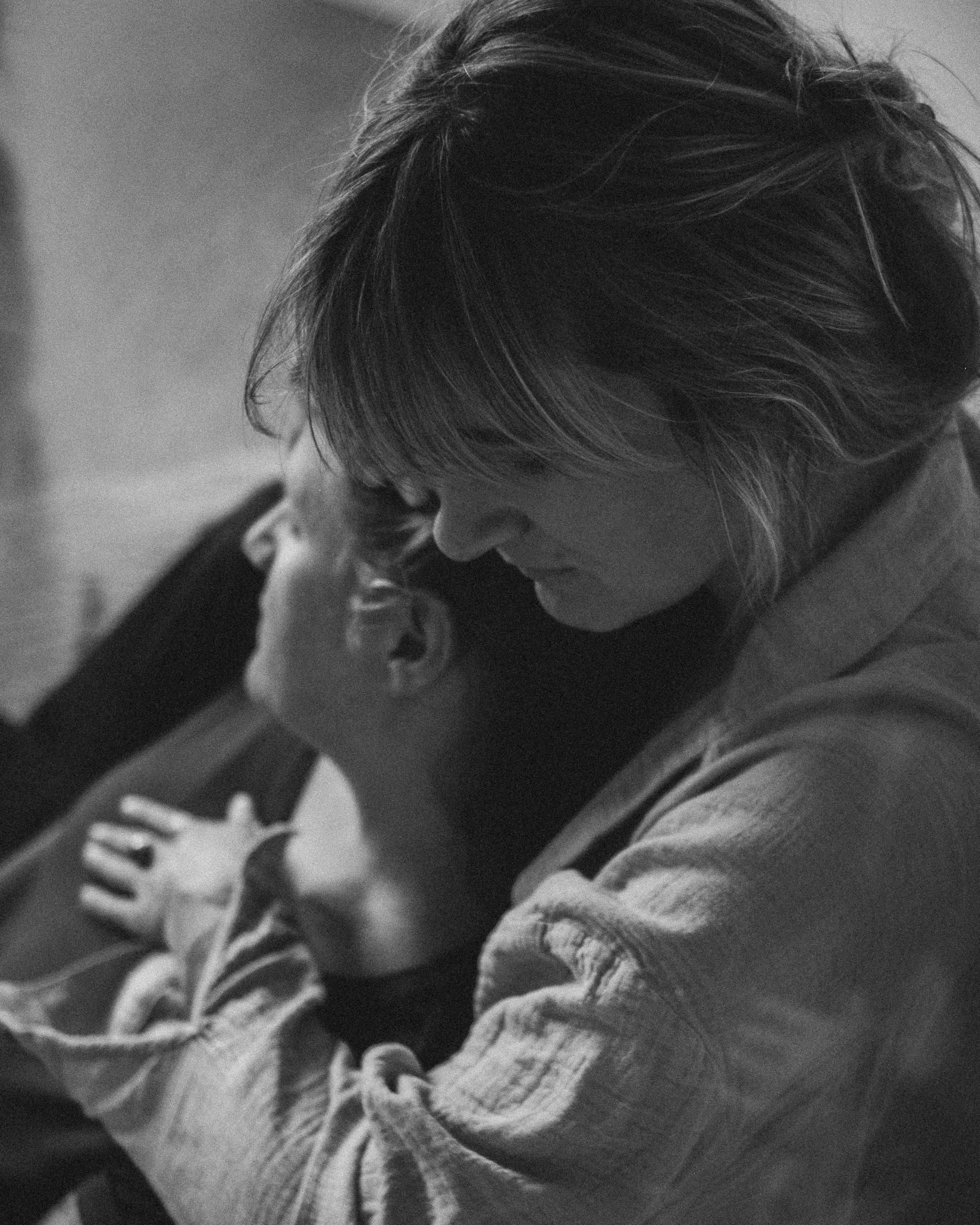 Schwarz-Weiß-Foto einer Frau, die eine Freundin liebevoll umarmt.