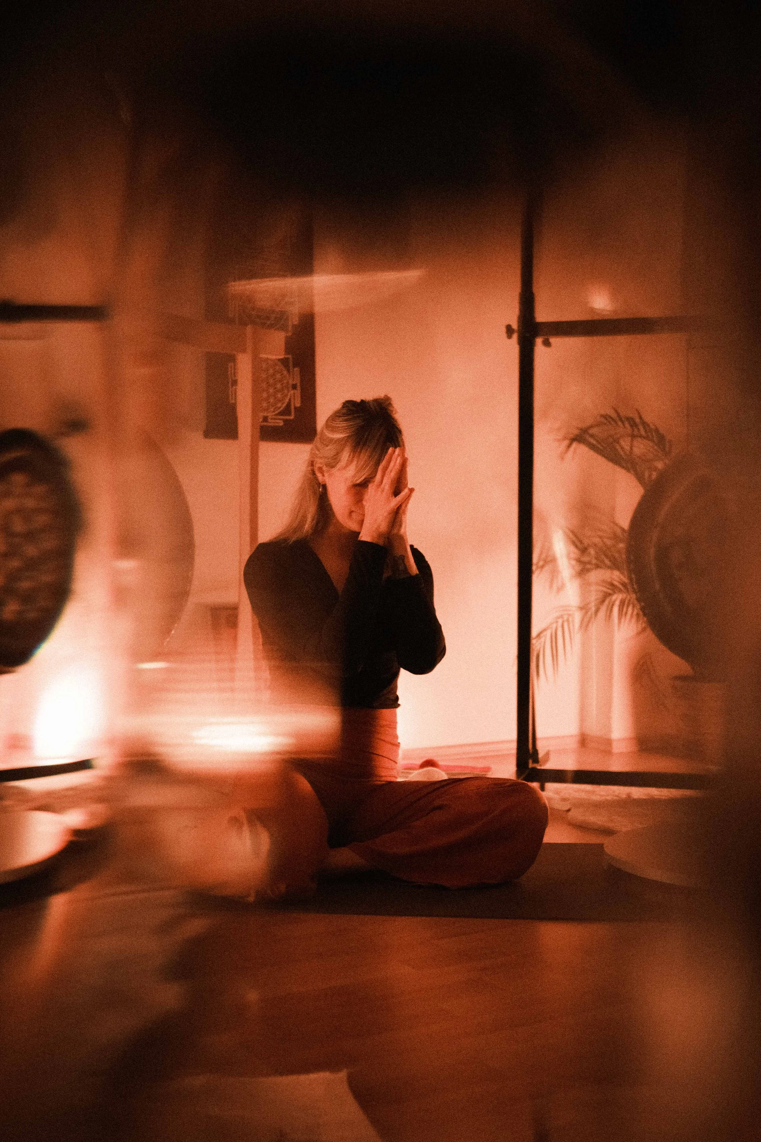 Frau in Anjali Mudra zwischen zwei Gongs.
