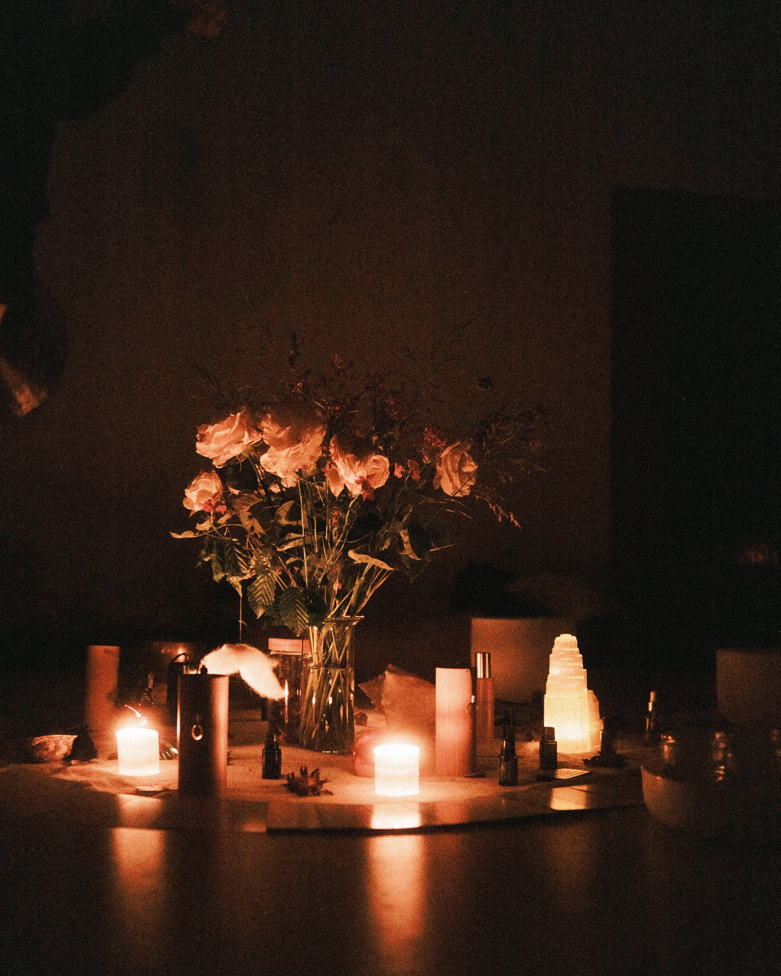 Kreis-Mitte eines Frauenkreises mit Blumenstrauß, Kristallen und Kerzen.