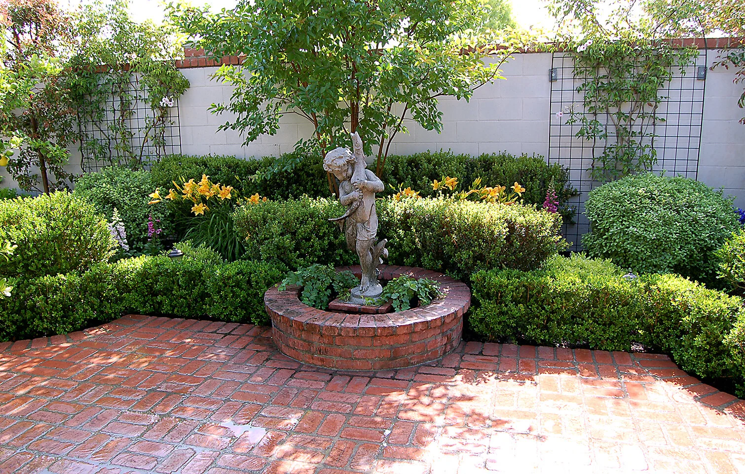 Clipped boxwood and brickwork create a timeless garden vignette