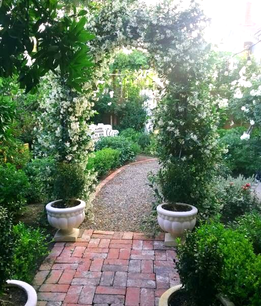 A romantic jasmine-covered arbor marks the entry to a secluded secret garden room