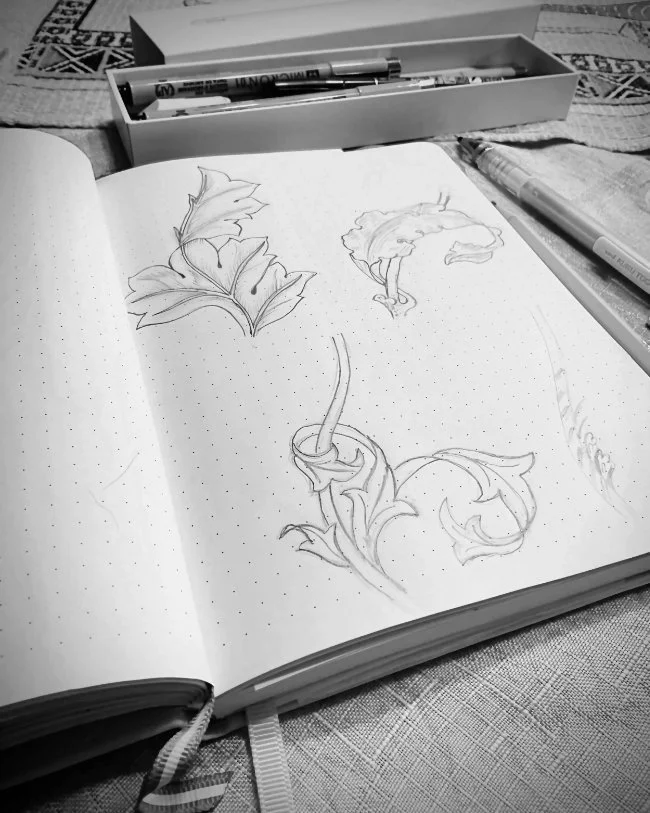Botanical sketches in a sketchbook during the early stages of surface pattern design development.
