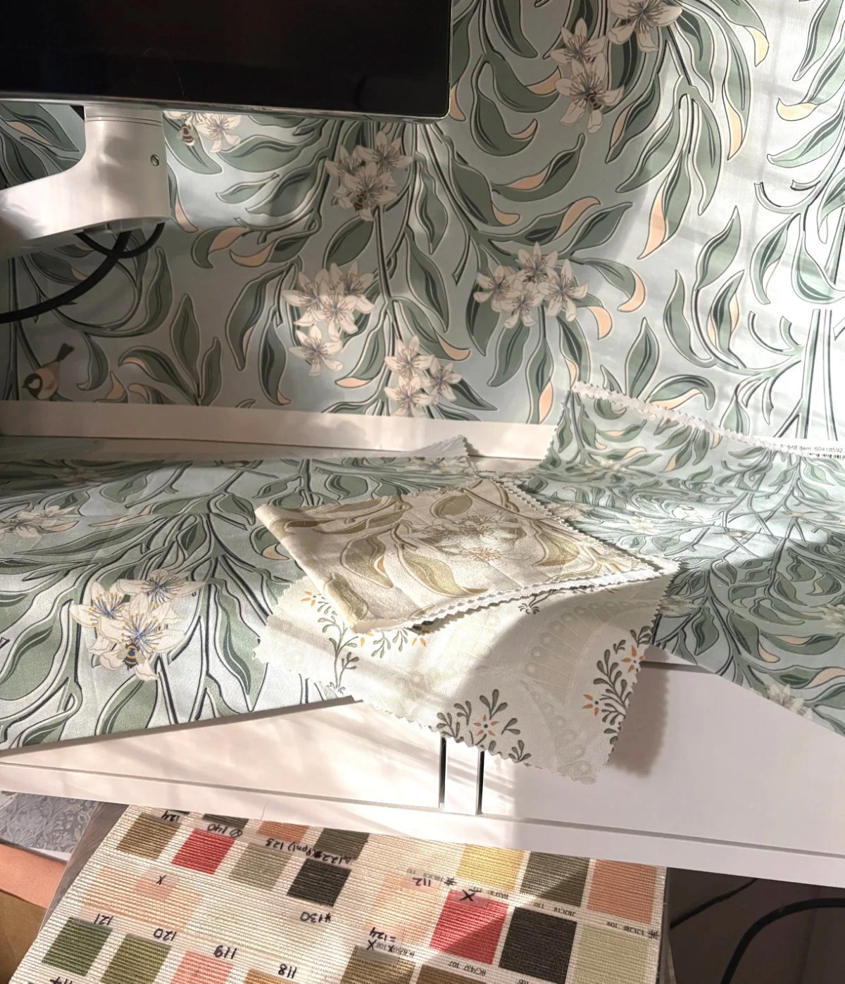 Wallpaper and fabric samples by Wild Geranium Design shown in an interior setting, demonstrating coordinated surface pattern collections for interiors.