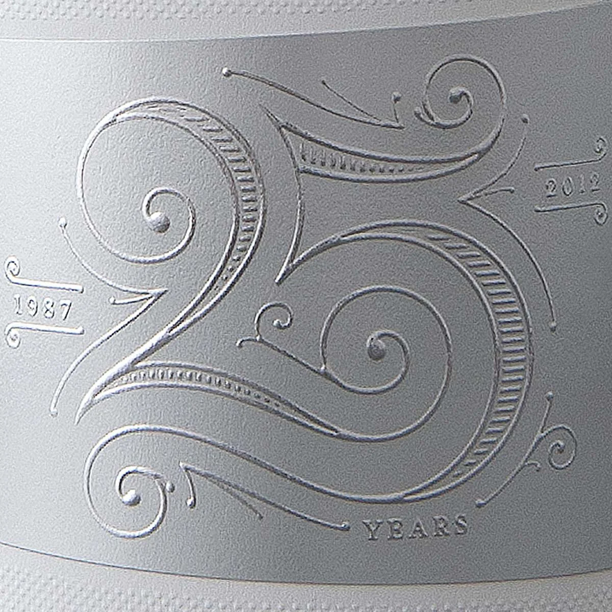 An image of an embossed label, celebrating Dessein's 25th year in 2012 as a award winning graphic design agency in Perth
