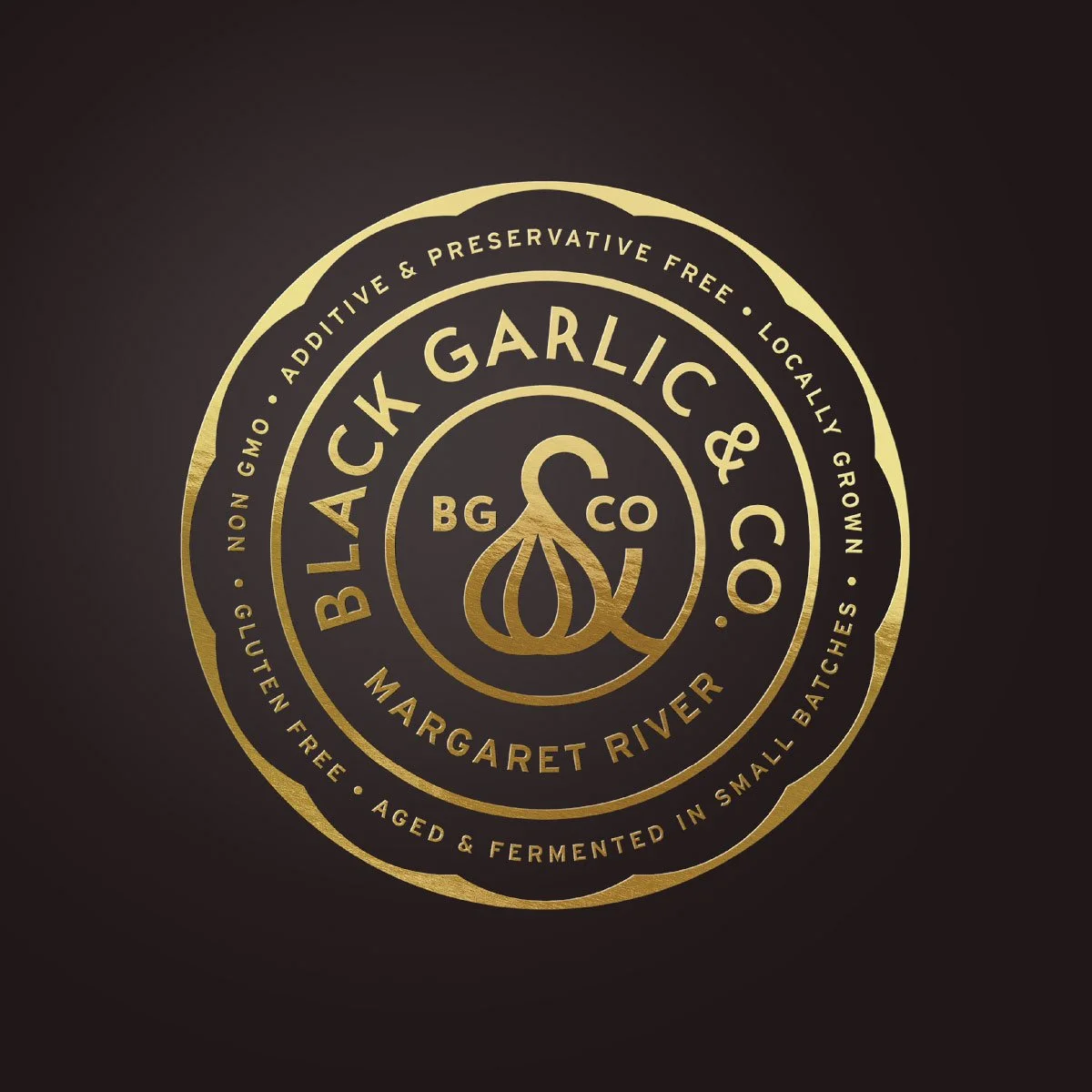 The Black Garlic & Co branded seal, embossed in gold on a black background designed by Dessein