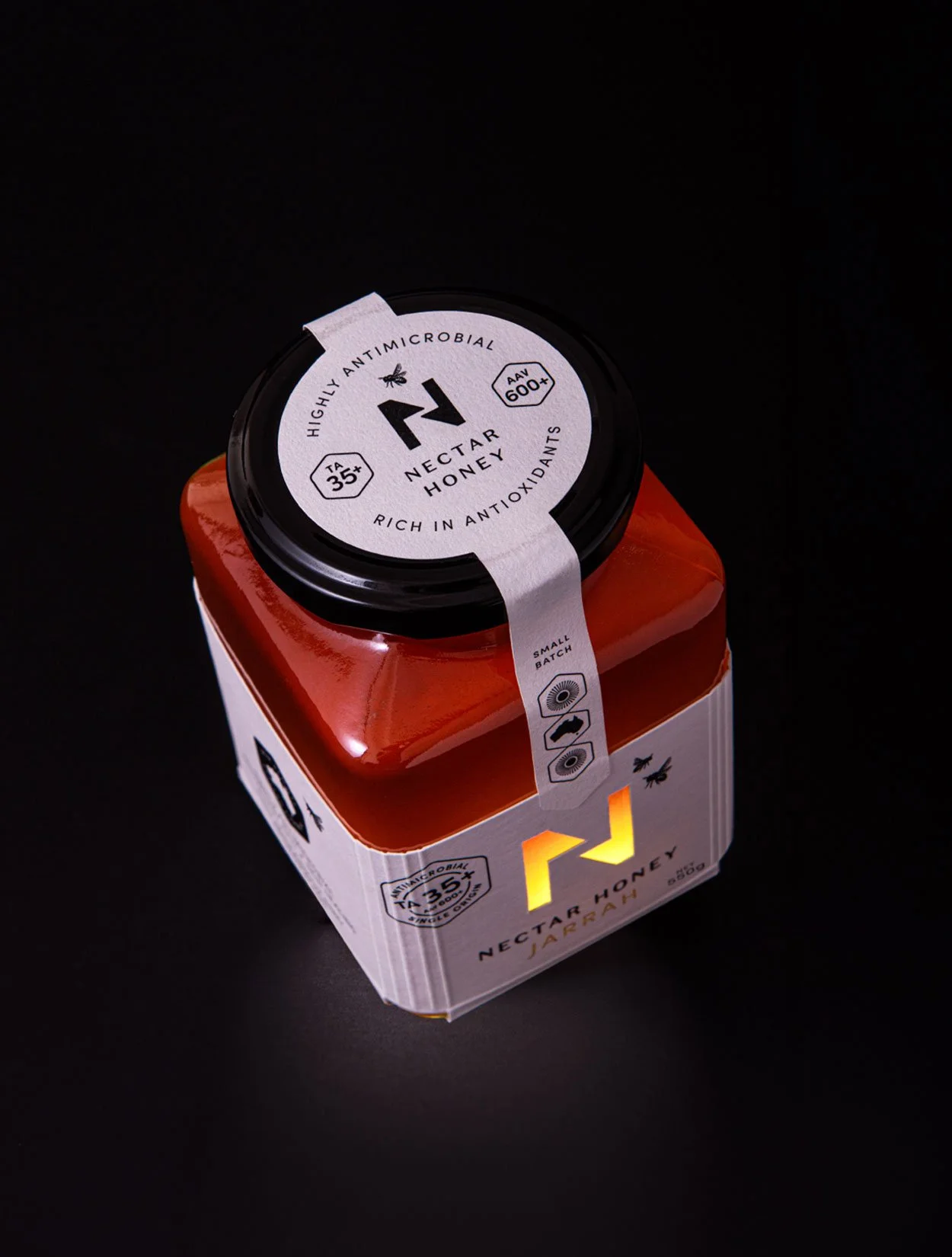 A stylised photograph of the top and front of the label design of Nectar Honey's Jarrah honey 550g size
