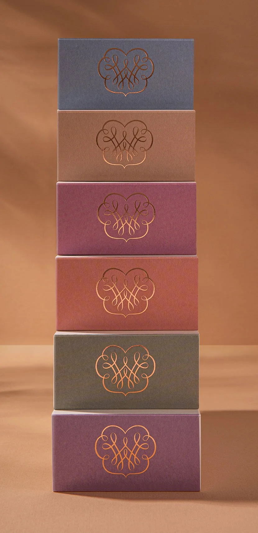 A photograph of Wattle and Wax Australia's reed diffuser boxes, showcasing the gold embossed brand mark on the top of each box