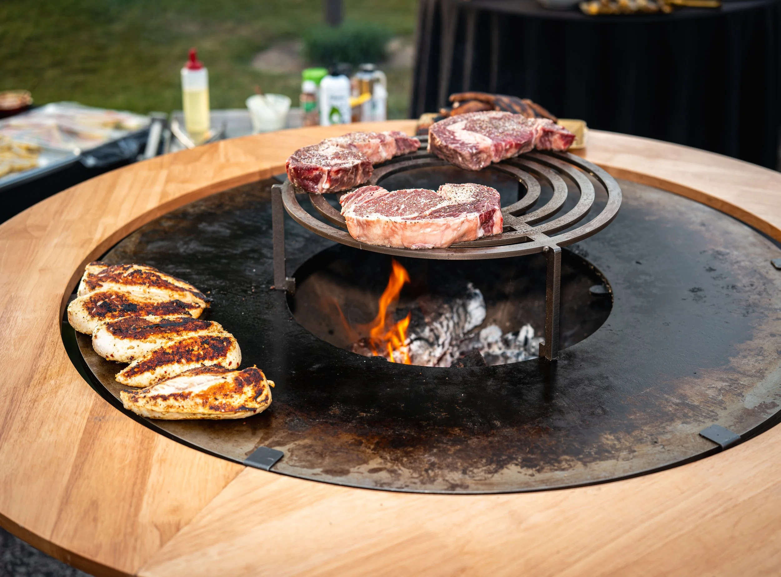 Steak cooking over live fire on Sudfire Hearth grill