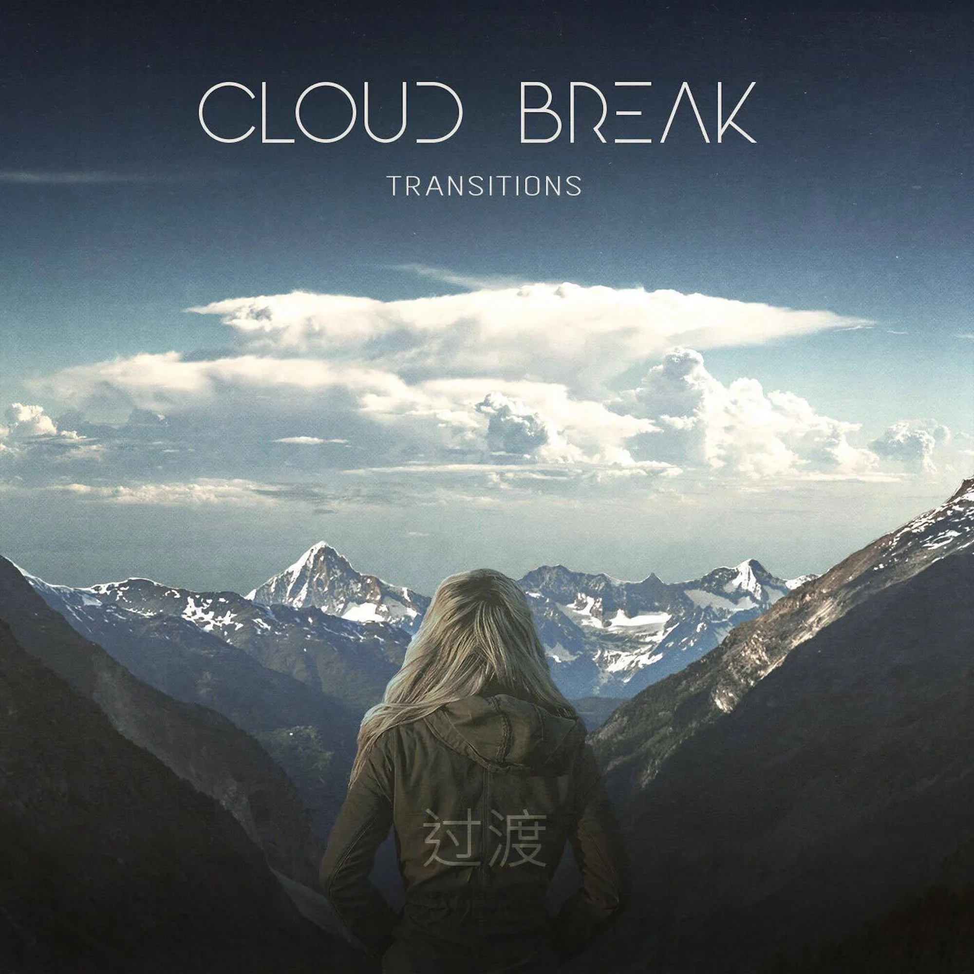 View of snow-capped mountains under a cloudy sky with a person in a green jacket facing the mountains. There are Chinese characters at the bottom of the image.
