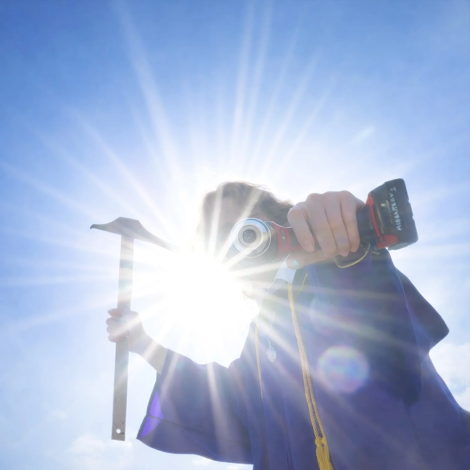 Person holding a hammer and a cordless drill, backlit by the sun in a clear blue sky.