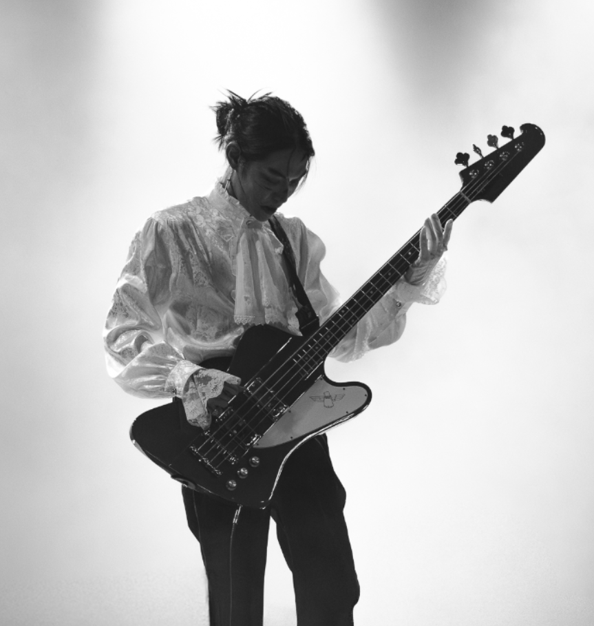 Une femme joue de la guitare électrique dans un style monochrome noir et blanc.