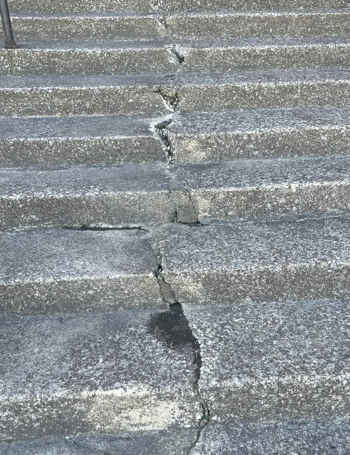 Concrete steps with cracks and damage.
